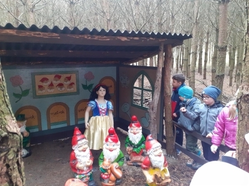 Dzieci oglądają figurkę Królewny Śnieżki i krasnoludków. 