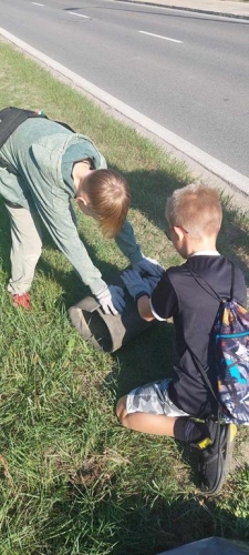 Dwóch chłopców przygotowuje znaleziony kawałek gumy do wyrzucenia.