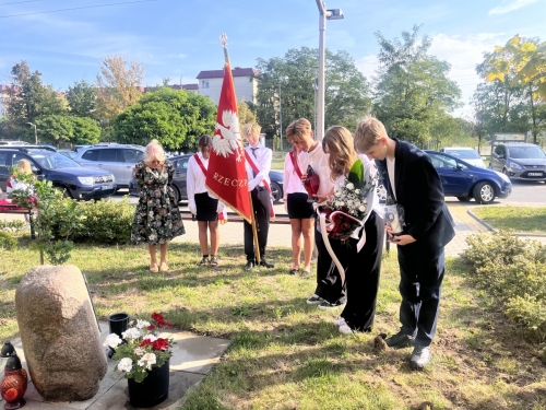 Uczniowie podczas składania kwiatów przed dębem pamięci posadzonym dla uhonorowania podpułkownika Aleksandra Tomaszewskiego. 